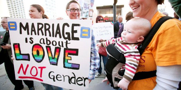 DETROIT, MI - OCTOBER 16: Kristen Vanderzouwen (R) of Grand Rapids, Michigan, her baby Alexzander, 3 months, Danielle Helgeson (C) of Allendale, Michigan and Melissa Schaub (L) of Allendale, Michigan attend a rally in favor of same-sex marriage at the U.S. Courthouse where U.S. District Judge Bernard Friedman will hold a hearing today that could overturn Michigan's ban on same-sex marriage October 16, 2013 in Detroit, Michigan. The lawsuit was brought by April DeBoer and Jayne Rowse, a gay couple who are raising three adopted children together. Michigan passed a constitutional amendment in 2004 that defined marriage as being between a man and a woman. (Photo by Bill Pugliano/Getty Images)