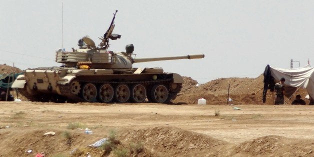 Members of Kurdish security forces, known as Peshmerga, stand near a tank as they patrol the Jihadist-controlled Bashir region, 25 kms south of the northern Iraqi city of Kirkuk, on June 20, 2014, following their deployment in the area to stop any advance towards the multi-ethnic city by the Sunni Muslim militants of the Islamic State of Iraq and the Levant (ISIL) who took over nearby areas in the north of the country after a lightning offensive against the Shiite-run government earlier this month. The rapid shift to Kurdish control in Iraq's oil-rich city of Kirkuk is a step toward a long-held dream for Kurds but has sparked fears among other groups. AFP PHOTO / MARWAN IBRAHIM (Photo credit should read MARWAN IBRAHIM/AFP/Getty Images)