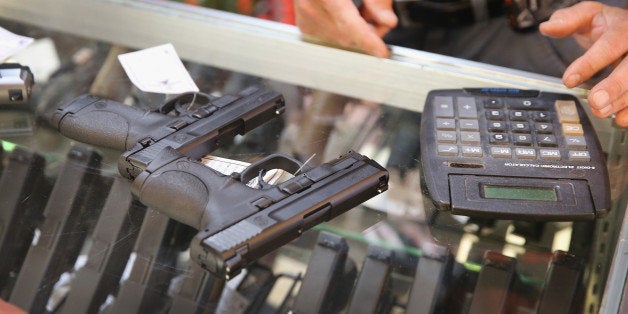 TINLEY PARK, IL - JUNE 16: A customer shops for a handgun at Freddie Bear Sports on June 16, 2014 in Tinley Park, Illinois. In a 5-4 decision the Supreme Court ruled that it is a crime for one person to buy a gun for another while lying to the dealer about who the gun is for. The law had been challenged by retired police officer Bruce Abramski who was charged with making a 'straw purchase' after buying a gun for his uncle, a lawful gun owner, in order to get a police discount at the dealer. When asked on the paperwork if the gun was for him he checked yes. (Photo by Scott Olson/Getty Images)