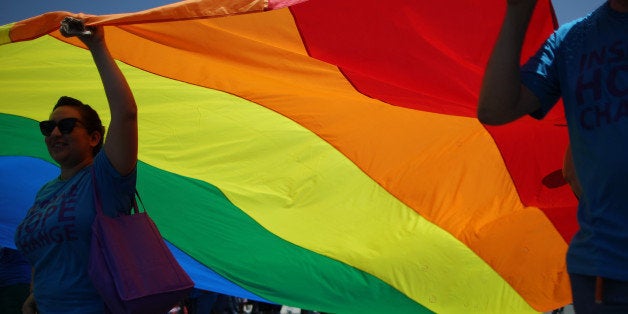 WEST HOLLYWOOD, CA - JUNE 8: Marchers carry a rainbow flag in the LA Pride Parade on June 8, 2014 in West Hollywood, Califor