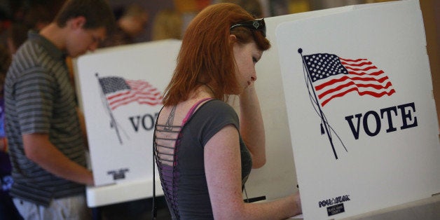 CEDAR FALLS, IA - SEPTEMBER 28: Student Courtney Johnson (R) votes on the campus of the University of Northern Iowa (UNI) on September 28, 2012 in Cedar Falls, Iowa. Voters filled the polling place which had been set up on campus for early voting following a nearby rally with first lady Michelle Obama. Yesterday Iowa began early voting in select locations throughout the state. (Photo by Scott Olson/Getty Images)