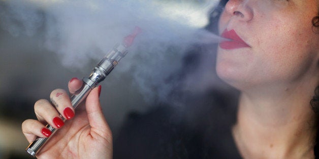 MIAMI, FL - APRIL 24: Julia Boyle enjoys an electronic cigarette as she waits for customers at the Vapor Shark store on April 24, 2014 in Miami, Florida. Brandon Leidel, CEO, Director of OperationsVapor Shark, said he welcomes the annoucement by the Food and Drug Administration that they are proposing the first federal regulations on electronic cigarettes, which would ban sales of the popular devices to anyone under 18 and require makers to gain FDA approval for their products. (Photo by Joe Raedle/Getty Images)