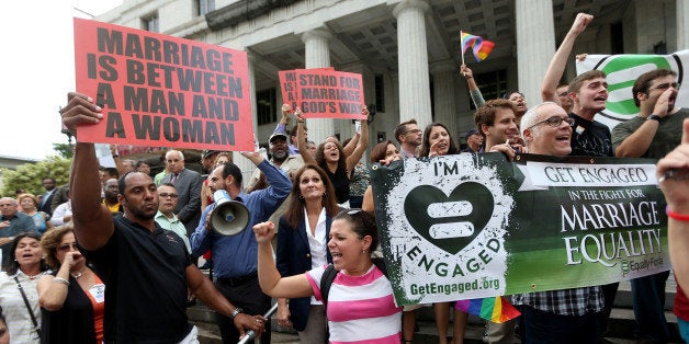 MIAMI, FL - JULY 02: Opponents of same-sex marriage stand behind a railing near supporters of the LGBTQ couples who are insi