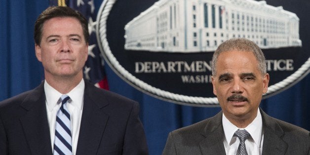 FBI Director James Comey (L) and US Attorney General Eric Holder announce a record 8.9 billion USD fine against the French bank BNP Paribas for violating international sanctions during a press conference at the US Justice Department in Washington on June 30, 2014. AFP PHOTO / Saul LOEB (Photo credit should read SAUL LOEB/AFP/Getty Images)