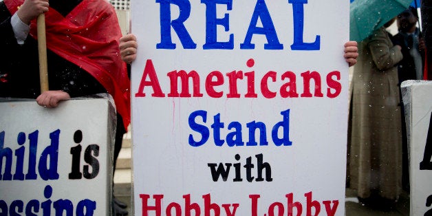 A demonstrator in favor of Hobby Lobby Stores Inc. and opposed to U.S. President Barack Obama's health-care law contraception requirement holds up a sign outside the U.S. Supreme Court in Washington, D.C., U.S., on Tuesday, March 25, 2014. A divided U.S. Supreme Court debated whether companies can assert religious rights, hearing arguments in an ideological clash over President Barack Obama's health care law and rules that promote contraceptive coverage. Photographer: Andrew Harrer/Bloomberg via Getty Images