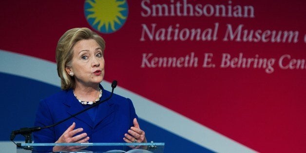 Former US Secretary of State Hillary Clinton delivers remarks during ceremonies naturalizing 15 new US citizens from 15 countries and to present designer Ralph Lauren(R) the James Smithson Bincentennial Medal June 17, 2014, at the Smithsonian National Museum of American History in Washington, DC. Lauren was honored for his contributions in preserving the original copy of the 'Star-Spangled Banner', the US national anthem. AFP Photo/Paul J. Richards (Photo credit should read PAUL J. RICHARDS/AFP/Getty Images)