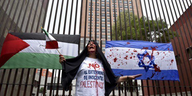 A pro-Palestinian activist shouts slogans during a rally against the Israeli military offensive in the Gaza strip outside the Mexican Foreign Ministry building in Mexico City on July 11, 2014. Israel's aerial bombardment of Gaza claimed its 103rd Palestinian life Friday as Hamas pounded central Israel with rockets and Washington offered to help broker a truce. AFP PHOTO/ Yuri CORTEZ (Photo credit should read YURI CORTEZ/AFP/Getty Images)