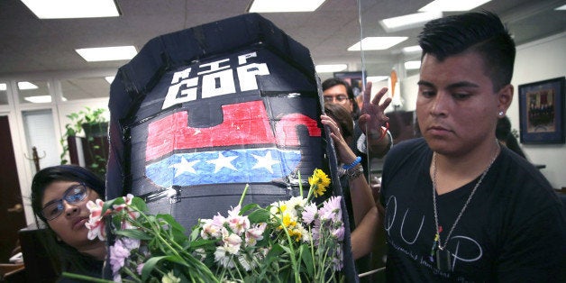 WASHINGTON, DC - JULY 21: Members of United We Dream, Maria Palacios (L) of Tampa, Florida, and others hold a mock coffin during a protest July 21, 2014 on Capitol Hill in Washington, DC. Activists staged 'funeral services for the Republican Party' because 'the GOP has embraced radical right-wing policies and has actively called for the separation of families and the deportation of Dreamers.' (Photo by Alex Wong/Getty Images)