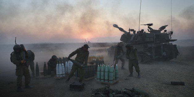 Israeli soldiers of the 155mm artillery cannons unit fire towards the Gaza Strip from their position near Israel's border with the coastal Palestinian enclave, on July 21, 2014. World efforts to broker a ceasefire in war-torn Gaza gathered pace as Israel pressed a blistering 14-day assault on the enclave, pushing the Palestinian death toll to 558. AFP PHOTO/MENAHEM KAHANA (Photo credit should read MENAHEM KAHANA/AFP/Getty Images)