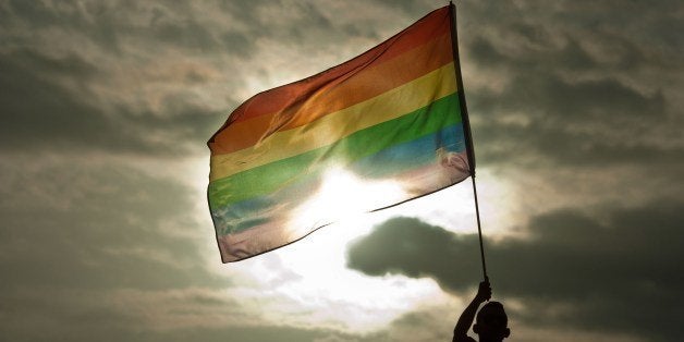 A person holds a rainbow flag during the Gay Pride Parade in San Salvador, El Salvador, on June 28, 2014. AFP PHOTO/ Jose CABEZAS (Photo credit should read JOSE CABEZAS/AFP/Getty Images)