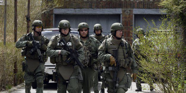 The Cape Cod, Massachusetts, Police Department SWAT team search houses for the second of two suspects wanted in the Boston Marathon bombings takes place April 19, 2013 in Watertown, Massachusetts. Thousands of heavily armed police staged an intense manhunt Friday for a Chechen teenager suspected in the Boston marathon bombings with his brother, who was killed in a shootout. Dzhokhar Tsarnaev, 19, defied the massive force after his 26-year-old brother Tamerlan was shot and suffered critical injuries from explosives believed to have been strapped to his body. AFP PHOTO / TIMOTHY A. CLARY (Photo credit should read TIMOTHY A. CLARY/AFP/Getty Images)
