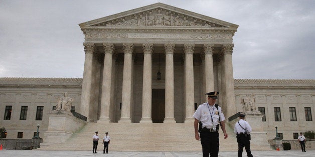 WASHINGTON, DC - JUNE 30: Police stand in front of the U.S. Supreme Court on June 30, 2014 in Washington, DC. Today the high court is expected to give its ruling on whether a private company can be exempted on religious grounds from health care reform's requirement that employer sponsored health insurance policies cover contraception. (Photo by Mark Wilson/Getty Images)