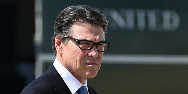 Texas Governor Rick Perry waits to greet US President Barack Obama in Dallas, Texas, on July 9, 2014 as he arrives for a meeting with local elected officials and faith leaders to discuss the urgent humanitarian situation at the Southwest border. Obama requested $3.7 billion in emergency funding from Congress to help cope with a surge of unaccompanied child immigrants from Central America. AFP PHOTO/Jewel Samad (Photo credit should read JEWEL SAMAD/AFP/Getty Images)