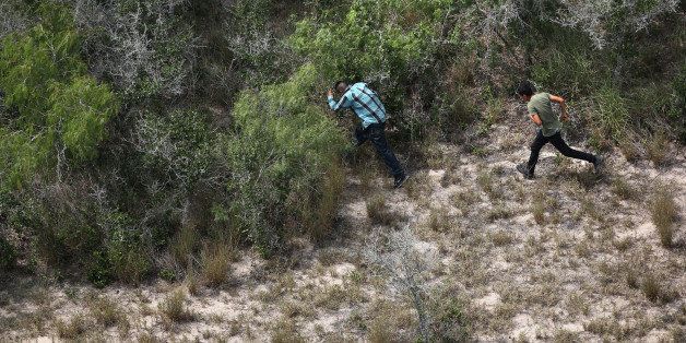 FALFURRIAS, TX - JULY 23: Undocumented immigrants flee into dense brush from U.S. Customs and Border Protection agents some 60 miles north of the U.S.-Mexico border in Brooks County on July 23, 2014 near Falfurrias, Texas. Thousands of immigrants, many of them minors, have crossed illegally into the United States this year, causing a humanitarian crisis on the U.S.-Mexico border. (Photo by John Moore/Getty Images)