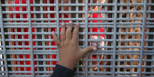 SAN DIEGO, CA - NOVEMBER 17: Family members reunite through bars and mesh of the U.S.-Mexico border fence at Friendship Park