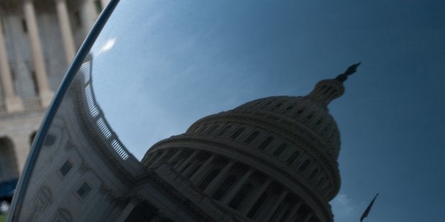 The US Capitol is reflected in the window of a car in Washington on September 30, 2013 as a government shutdown looms over a