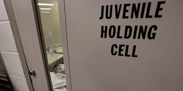 BROWNSVILLE, TX - JUNE 18: A sleeping detainee is see through the window of holding cell at a U.S. Customs and Border Protection processing facility, on June 18, 2014, in Brownsville,Texas. Brownsville and Nogales, Ariz. have been central to processing the more than 47,000 unaccompanied children who have entered the country illegally since Oct. 1. (Photo by Eric Gay-Pool/Getty Images)