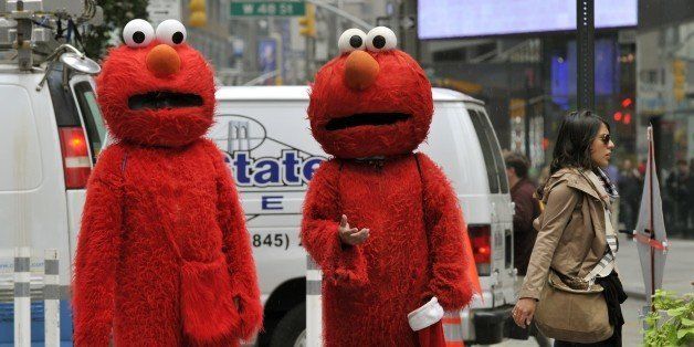 People, dressed as Elmo from the television show Sesame Street, wait to pose for pictures with tourists in through Times Square October 4, 2012. GOP Presidential nominee Mitt Romney mentioned Sesame Street in Wednesday night's debate when he vowed to cut funding to public broadcasting if elected. PBS's Sesame Street will be celebrating its 43rd birthday this year. AFP PHOTO/ TIMOTHY A. CLARY (Photo credit should read TIMOTHY A. CLARY/AFP/GettyImages)
