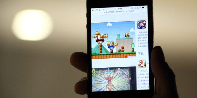 The download page of the 'Super Mario' game on the Beijing Flyfish Technology Co. website is displayed on a smartphone in this arranged photograph taken in Tokyo, Japan, on Thursday, Feb. 20, 2014. A game called 'Super Mario' was available to download on Baidu Inc.s 91 Wireless online app store in China and yesterday was available on Samsung Electronics Co.s online China app store. Photographer: Tomohiro Ohsumi/Bloomberg via Getty Images