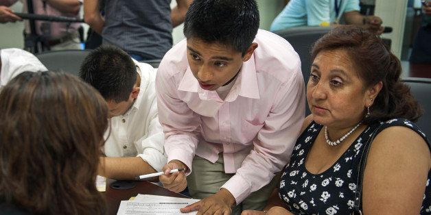 Bolivian Diego Mariaca(C), his mother Ingrid Vaca(R) and brother Gustavo Mariaca(L) fill out paperwork under the 'Dream Act' August 15, 2012 at the National Immigration Forum in Washington, DC. In June US President Barack Obama announced that hundreds of thousands of undocumented young people known as 'Dreamers' could apply for deferred action and work permits in the wake of the historic DHS decision that will protect them from deportation. AFP PHOTO/Paul J. Richards (Photo credit should read PAUL J. RICHARDS/AFP/GettyImages)