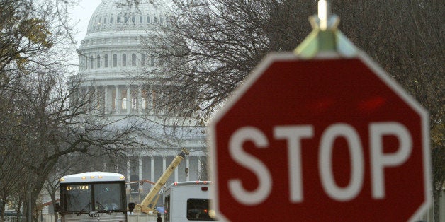 WASHINGTON - NOVEMBER 19: Busses travel near a traffic checkpoint stop sign on East Capitol Street in Washington, DC on November 19, 2004. The checkpoints around the U.S. Capitol are part of a temporary security perimeter that was set up around the U.S. Capitol in August. (Photo by Matthew Cavanaugh/Getty Images)