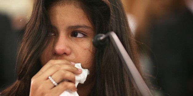 WASHINGTON, DC - JULY 29: Twelve-year-old Mayeli Hernandez wipes tears as she tells her story of escaping her home country of Honduras in July of 2013, due to increasing violence, during a hearing before the Congressional Progressive Caucus July 29, 2014 on Capitol Hill in Washington, DC. The caucus held a hearing titled 'Kids First: Examining the Southern Border Humanitarian Crisis.' (Photo by Alex Wong/Getty Images)