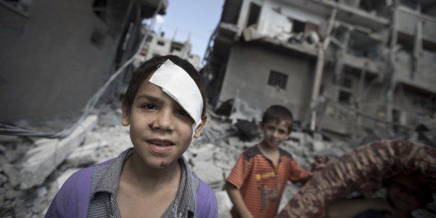 Palestinian boys look on as they inspect the rubble of a house after it was destroyed by an Israeli military strike in the Jabalia refugee camp, in the northern Gaza Strip, on August 9, 2014. Israeli warplanes pounded targets in Gaza, a day after killing at least five Palestinians, and militants fired dozens of rockets into Israel after attempts to extend a three-day truce stalled. AFP PHOTO / MAHMUD HAMS (Photo credit should read MAHMUD HAMS/AFP/Getty Images)