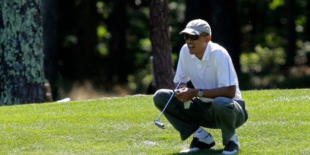 OAK BLUFFS, MA - AUGUST 09: President Barack Obama lines up a putt on the first green at the Farm Neck Golf Club on August 9, 2014 in Oak Bluffs, Massachusetts. The Obama's are vacationing on the island for two weeks. (Photo by Matthew Healey-Pool/Getty Images)