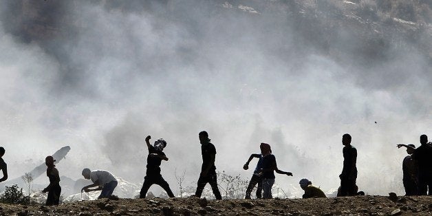 Palestinian protesters clash with Israeli security forces (unseen) following a demonstration in support of Gaza after Friday