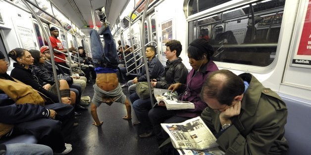 New York City Subway dancer Marcus Walden aka 'Mr Wiggles' performs acrobatic tricks on the subway while passengers watch November 23, 2010. The dance crew of Donte Steele (Thebestuknow); Tamiek Steele ( B/Boy LJ) and Marcus Walden ( Mr Wiggles) perform their roughly 45-second routine between stops on the train running from 125th Street in Harlem to the Brooklyn Bridge . AFP PHOTO / TIMOTHY A. CLARY (Photo credit should read TIMOTHY A. CLARY/AFP/Getty Images)