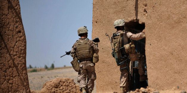 US Marines Corporal Fernando Uribe (R) and Doc. Arthur Carter (L) from Combat Operation Patrol (COP) Bandini of 2nd Batallion 8 Marine (2/8) Weapons Company 81's Platoon search for weapons at an insurgent's compound in Sistani, Helmand Province, on May 8, 2011.There are about 130,000 international forces deployed in Afghanistan under the leadership of the United States to defeat a Taliban-led insurgency fighting since the US-led invasion of the troubled nation in 2001. AFP PHOTO/Bay ISMOYO (Photo credit should read BAY ISMOYO/AFP/Getty Images)