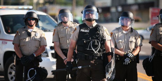 FERGUSON, MO - AUGUST 13: Police watch over demonstrators protest the shooting death of teenager Michael Brown on August 13, 2014 in Ferguson, Missouri. Brown was shot and killed by a Ferguson police officer on Saturday. Ferguson, a St. Louis suburb, has experienced three days of violent protests since the killing. (Photo by Scott Olson/Getty Images)