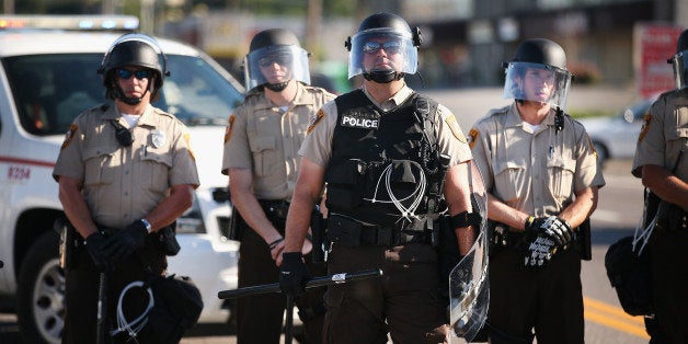 FERGUSON, MO - AUGUST 13: Police watch over demonstrators protest the shooting death of teenager Michael Brown on August 13, 2014 in Ferguson, Missouri. Brown was shot and killed by a Ferguson police officer on Saturday. Ferguson, a St. Louis suburb, has experienced three days of violent protests since the killing. (Photo by Scott Olson/Getty Images)