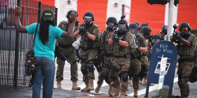 FERGUSON, MO - AUGUST 11: Police force protestors from the business district into nearby neighborhoods on August 11, 2014 in