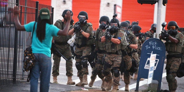 FERGUSON, MO - AUGUST 11: Police force protestors from the business district into nearby neighborhoods on August 11, 2014 in Ferguson, Missouri. Police responded with tear gas and rubber bullets as residents and their supporters protested the shooting by police of an unarmed black teenager named Michael Brown who was killed Saturday in this suburban St. Louis community. Yesterday 32 arrests were made after protests turned into rioting and looting in Ferguson. (Photo by Scott Olson/Getty Images)