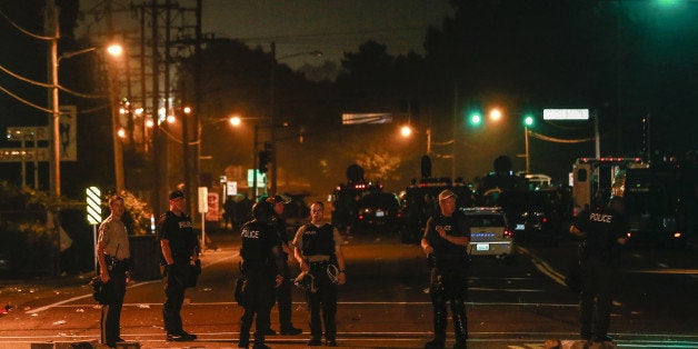 FERGUSON, UNITED STATES - AUGUST 18: Protests in the Missouri city of Ferguson over the death of an 18-year-old black man, erupted following the release of the name of the police officer who shot him, continue on August 18, 2014. Despite curfew in Ferguson being extended to a second day on Sunday, the night proved to be as chaotic as the previous ones, Missouri Governor Jay Nixon has ordered the deployment of the National Guard to the area. Protestors have rallied for nearly a week following Brown's death on Aug. 9, which ignited racial tensions in the predominantly black city. (Photo by Bilgin Sasmaz/Anadolu Agency/Getty Images)