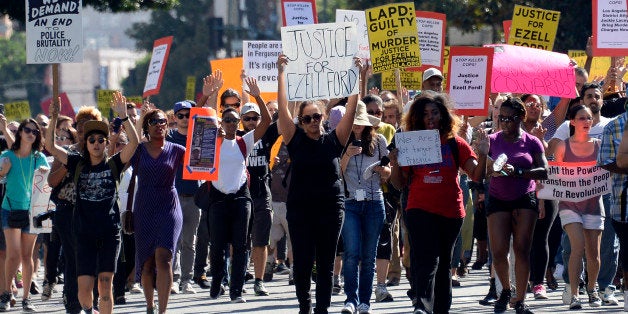 LOS ANGELES, CA - AUGUST 17: Demonstrators march in downtown Los Angeles protesting the police shooting death of 24-year-old Ezell Ford earlier in the week August 17, 2014, in Los Angeles, California. Several hundred protestors rallied in front of the Los Angeles Police Department headquarters to protest against recent police shootings in both Los Angeles and Missouri. (Photo by Kevork Djansezian/Getty Images)