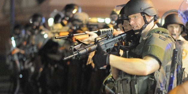 Law enforcement officers watch on during a protest on West Florissant Avenue in Ferguson, Missouri on August 18, 2014. Police fired tear gas in another night of unrest in a Missouri town where a white police officer shot and killed an unarmed black teenager, just hours after President Barack Obama called for calm. AFP PHOTO / Michael B. Thomas (Photo credit should read Michael B. Thomas/AFP/Getty Images)