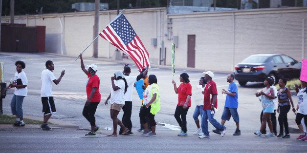 FERGUSON, MO - AUGUST 22: Demonstrators protest the death of Michael Brown on August 22, 2014 in Ferguson, Missouri. Brown was shot and killed by a Ferguson police officer on August 9. Despite the Brown family's continued call for peaceful demonstrations, violent protests have erupted nearly every night in Ferguson since his death. (Photo by Scott Olson/Getty Images)