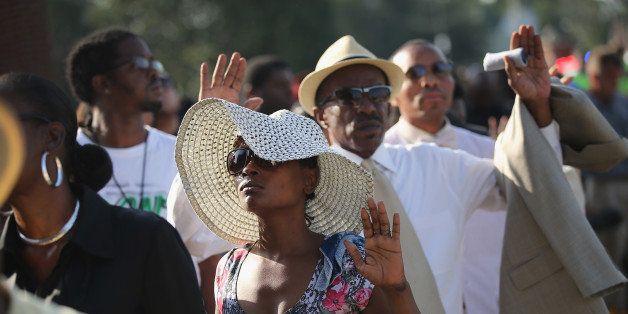 ST LOUIS, MO - AUGUST 25: Guests raise their hands as they wait in line to enter the Friendly Temple Missionary Baptist Church for the funeral of Michael Brown on August 25, 2014 in St. Louis, Missouri. Michael Brown, an 18 year-old unarmed teenager, was shot and killed by Ferguson Police Officer Darren Wilson in the nearby town of Ferguson, Missouri on August 9. His death caused several days of violent protests along with rioting and looting in Ferguson. (Photo by Scott Olson/Getty Images)