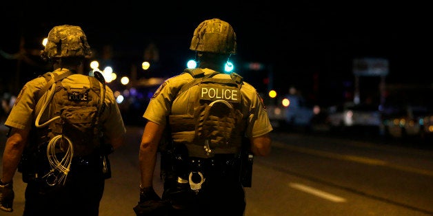 Police try to disperse a crowd of protesters Wednesday, Aug. 20, 2014, in Ferguson, Mo. The protests were sparked after Michael Brown, an unarmed black man was shot and killed by Darren Wilson, a white Ferguson police officer on Aug. 9, 2014. (AP Photo/Jeff Roberson)