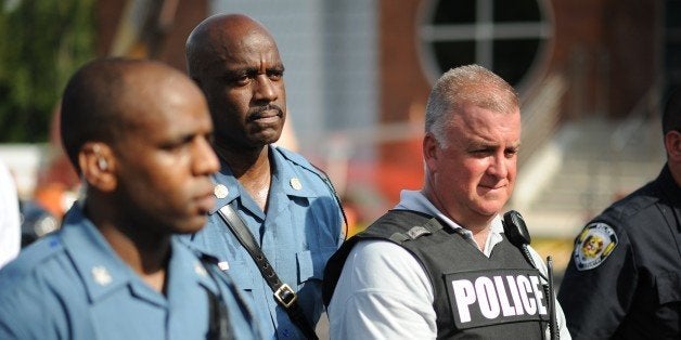 Captan Ronald Johnson (2L) of the Missouri Highway Patrol listens to the concerns of the protestors during the peaceful National March on Ferguson outside the Ferguson Police Department in Ferguson, Missouri on August 30, 2014. The protesters demanded justice for Michael Brown, 18, shot dead in a fatal encounter with police in Ferguson, Missouri, a St Louis suburb, on August 9. AFP PHOTO/Michael B. Thomas (Photo credit should read Michael B. Thomas/AFP/Getty Images)