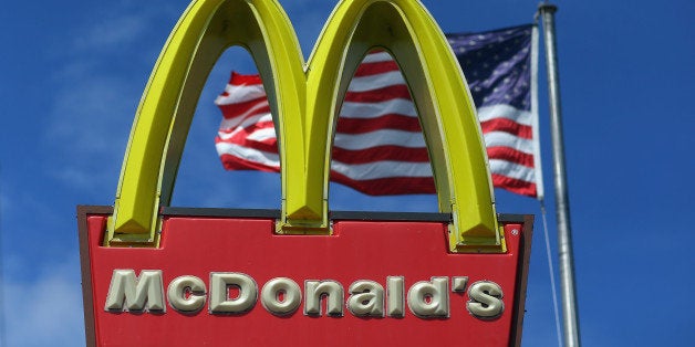 MIAMI, FL - JULY 23: A sign for a McDonald's restaurant sits in front of an American Flag July 23, 2012 in Miami, Florida. T
