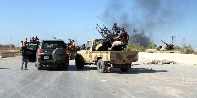 TRIPOLI, LIBYA - AUGUST 24: Militants of Fajr Libya (Libyan Dawn) coalition make an appearance at the entrance of the International Tripoli Airport after seizing the control of the airport after a month-long battle in Tripoli, Libya on August 24, 2014. (Photo by Hazem Turkia/Anadolu Agency/Getty Images)