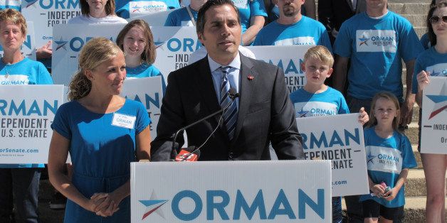 Greg Orman, right, an independent candidate for the U.S. Senate in Kansas, discusses his campaign during a news conference, as his wife, Sybil, watches to his left, Monday, July 28, 2014, on the south steps of the Statehouse in Topeka, Kan. Orman is portraying himself as the leading challenger for Republican Sen. Pat Roberts' seat. (AP Photo/John Hanna)