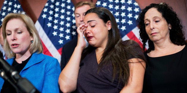 UNITED STATES - JULY 30: Anna, a victim of a campus sexual assault who declined to provide her last name, becomes emotional during a news conference in the Capitol Visitor Center to introduce legislation that aims to curb sexual assaults at universities, July 30, 2014. Also appearing are Sen. Kirsten Gillibrand, D-N.Y., left, Dean Heller, R-Nev., and Anna's mother Susan. (Photo By Tom Williams/CQ Roll Call)