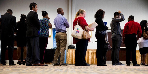 In this June 23, 2014 photo, job seekers wait in line to meet with recruiters during a job fair in Philadelphia....