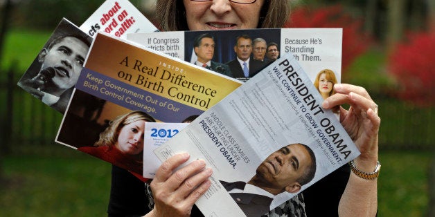 In this photo taken Oct. 19, 2012, Jean Gianfagna displays some of the political mailers her family receives at her home in