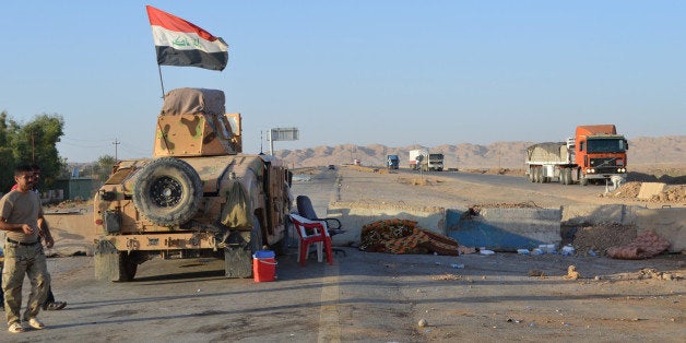 SALADIN, IRAQ - SEPTEMBER 07: Lorries and a tank are on the Kirkuk - Baghdad road in Suleiman Bey, town of Tuz Khurmato, Iraq, on September 7, 2014. The road from Kirkuk to Baghdad has reopened after being closed three months following some regions being captured by the Islamic State of Iraq and the Levant (ISIL). Checkpoints have now been set up along the road by the Iraqi armed forces and Peshmerga forces. (Photo by Adem Demir/Anadolu Agency/Getty Images)