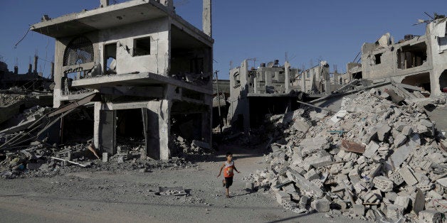 A Palestinian boy runs between the rubble of houses which were hit by an Israeli strikes in Beit Hanoun, in the northern Gaza Strip, Wednesday, Aug. 27, 2014. The third Gaza War in six years appears to have ended in another sort of tie, with both Israel and Hamas claiming the upper hand. Their questionable achievements have come at a big price, especially to long-suffering Palestinians in Gaza. (AP Photo/Adel Hana)